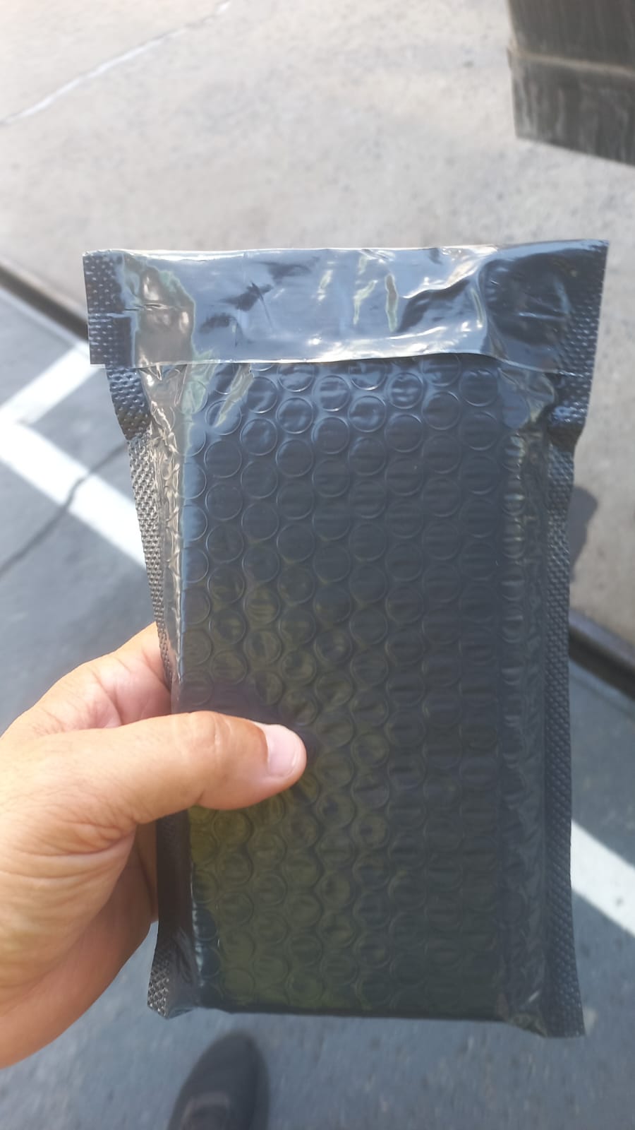 Envelope acolchoado sendo segurado para entrega